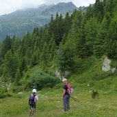 escursionisti sul sentiero per lago delle malghette di commezzadura folgarida