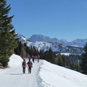 sentiero fuchiade inverno escursionisti e dietro monte civetta